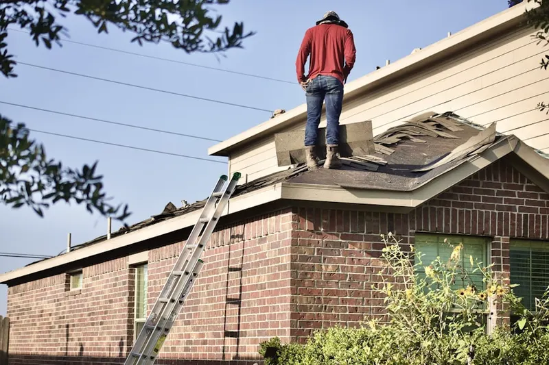 Professional roofer working on a residential roof in Howe